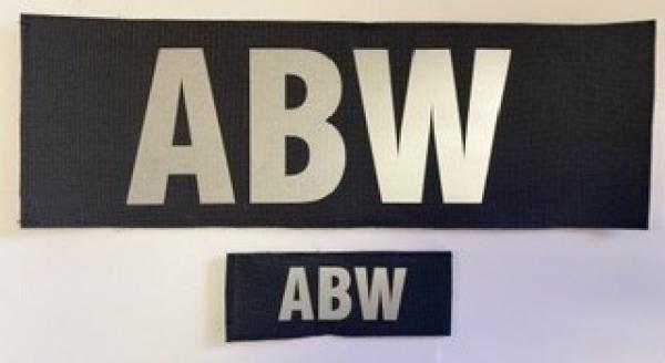 Napis ABW srebrny na czarnej kodurze mały
